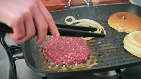 Frying onion rings and burger ingredients on the grill in 4K. Stock Footage 153755753