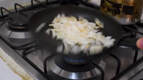 Frying Onions in Pan on Stove, Sauteing Onion on Kitchen Burner, Cooking Chopped Stock Footage 315193953