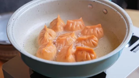 Frying Orange Dumplings In Blue Nonstick Pan Stock Footage 340856727