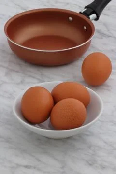 Frying pan and eggs on kitchen counter Stock Photos