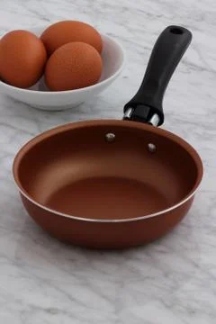 Frying pan and eggs on kitchen counter Stock Photos