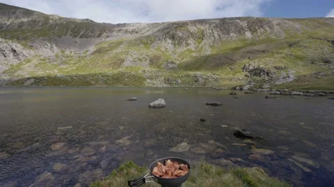A frying pan of bacon at a beautiful lakeside spot in the mountains Vídeo Stock 160188472