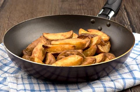 Frying pan with chips on a wooden table. Foto stock