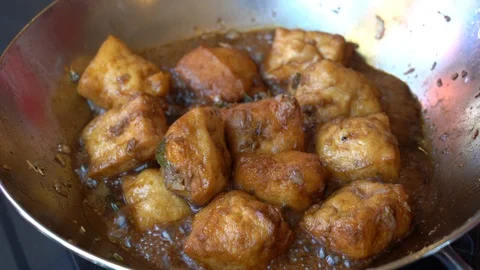 Frying pan with chopped garlic, green pepper and tofu on hot plate. Indonesia Stock Footage 114328005
