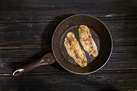 Frying pan with delicious fish on pan wooden background Stock Photos