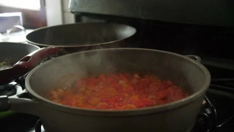Frying Pan with Diced Onion and Tomato over a Stove Top Stock Footage 199506687