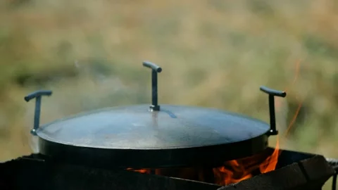 Frying pan from disc harrow with a lid for cooking over an open fire. Stock Footage 134083823