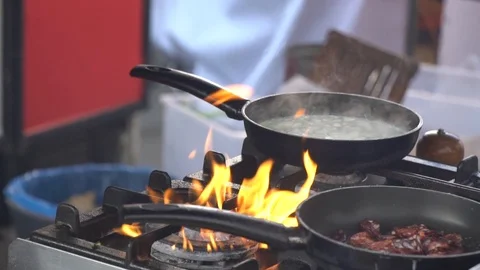 Frying pan on fire, chef Frying vegetables on fire throwing them in a frying pan Stock Footage 106008215