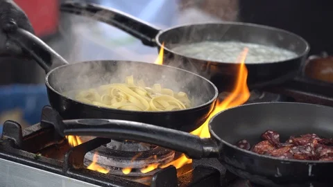 Frying pan on fire, chef Frying vegetables on fire throwing them in a frying pan Stock Footage 106008236