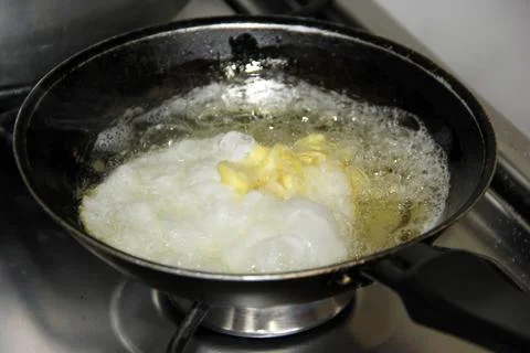 Frying pan with fried egg and a lot of oil Stock Photos