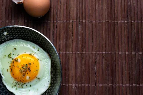 Frying pan with fried egg on a bamboo table Stock Photos