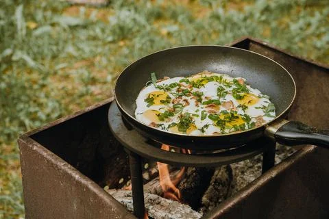 Frying pan of fried eggs, bacon and organic greens, green grass on the Stock-Fotos