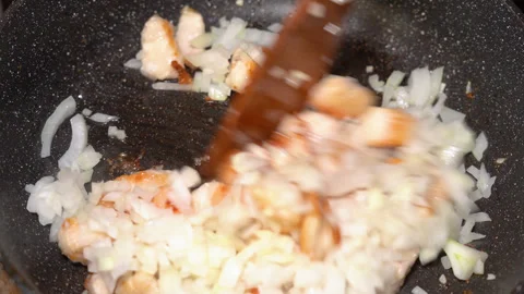 In a frying pan, fried meat and onions are mixed with a wooden spatula Stock Footage 248228515