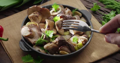 Frying pan with fried porcini mushrooms stands on a vintage wooden table. Video stock 149122553