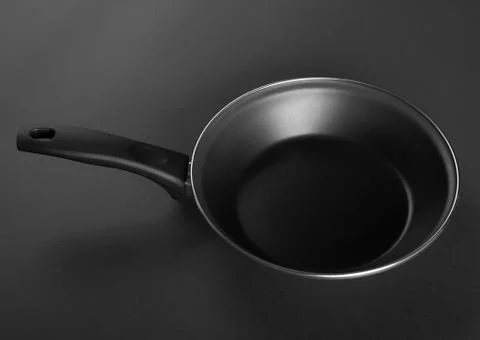 Frying pan with handle on black background. Top view Fotos Stock