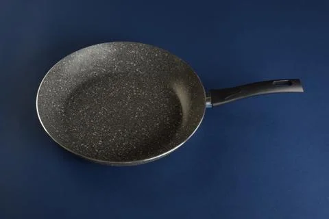 Frying pan with handle on blue background. Top view Photos
