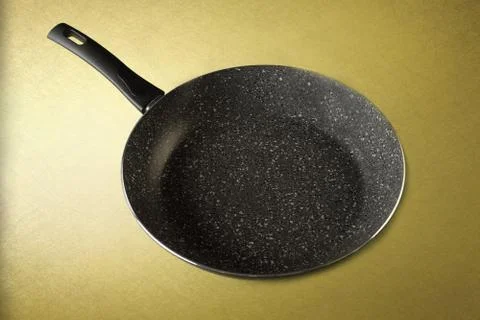 Frying pan with handle on yellow background. Top view Photos