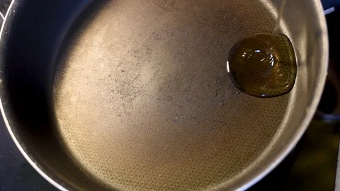 Frying pan on a hot plate with vegetable oil and pieces of dough Stock Footage 95097427