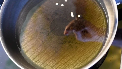 Frying pan on a hot plate with vegetable oil and pieces of dough Stock Footage 95110557