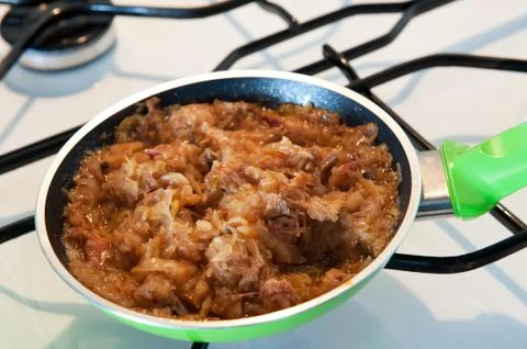 Frying pan with hot Polish bigos Stock Photos