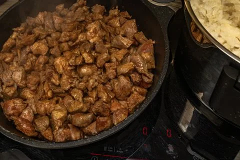 Frying pan on an induction hob, mixing sliced ??beef, pork, and bacon in a .. Stock Photos