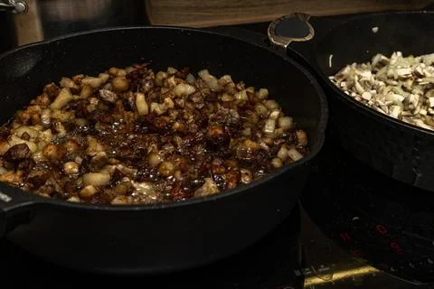 Frying pan on an induction hob, mixing sliced ??beef, pork, and bacon in a .. Stock Photos