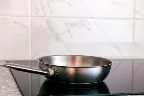 Frying pan is on induction hob. Stock Photos