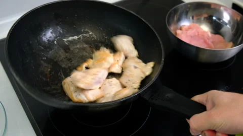 Frying Pan. Man Holds Frying Pan by Handle. Fries Meat. Throws Chicken Pieces Stock Footage 147047698
