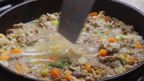 In a frying pan with minced meat and vegetables, udon noodles are mixed wit.. Vidéo 297098081