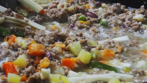 In a frying pan with minced meat and vegetables, stir the udon with a spoon.. Vidéo 300208214