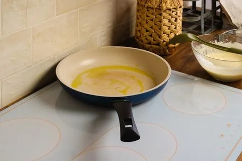 Frying pan with olive oil on a kitchen stove Stock Photos