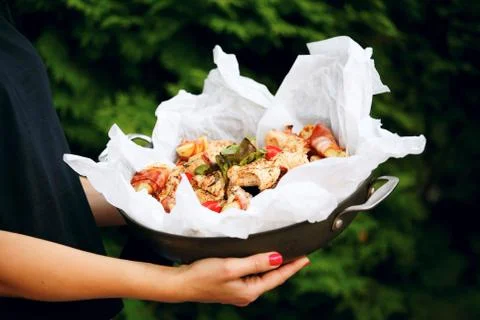 Frying pan with pieces of different meat. Chicken skewers with basil leaves.  Stock Photos