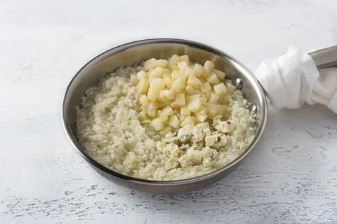 Frying pan risotto, cooking step by step, step 6, adding pear and blue chee.. Stock Photos