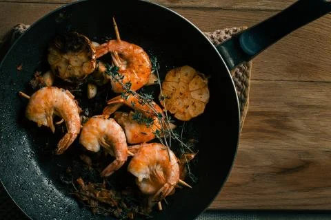 Frying pan with roasted prawns on the table Stock Photos