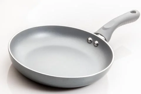 Frying pan skillet with grey surface on white background. Stock Photos