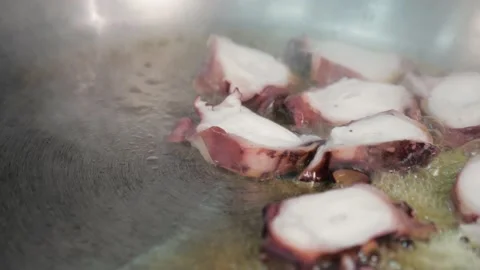 Frying pan on the stove.chef throws pieces of octopus for cooking in restaurant Vídeos de archivo 163971256
