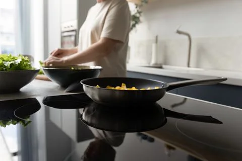 Frying pan with vegetable meal on induction cooker close up Photos