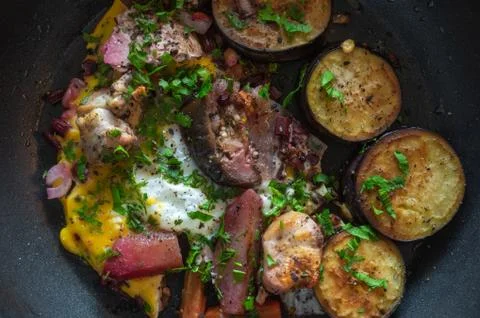 Frying pan with vegetables, egg and pieces of turkey meat Foto stock