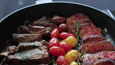 The frying pan in which the steak slices lie rotates clockwise. 库存影片 200203739