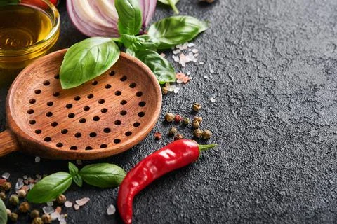 Frying pan white , black empty plate, basil leaves and spices on dark stone b Stock Photos