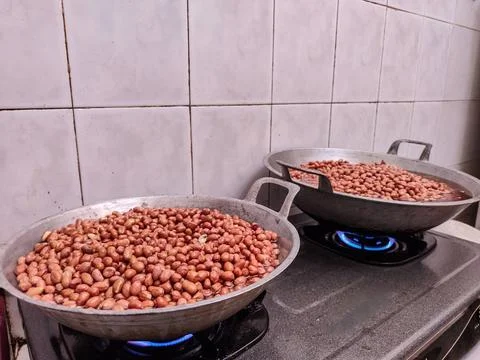 Frying peanuts in large quantities is part of the process of making Madiun'.. Stock Photos