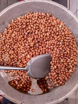Frying peanuts in large quantities is part of the process of making Madiun'.. Stock Photos