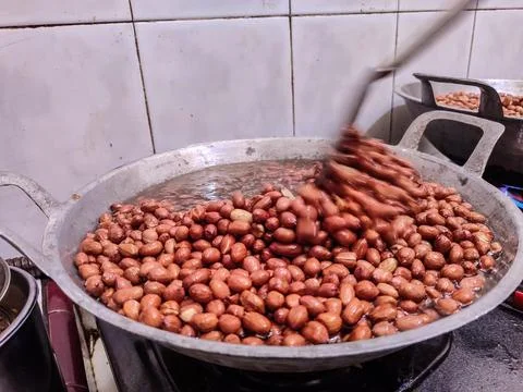 Frying peanuts in large quantities is part of the process of making Madiun'.. Stock Photos