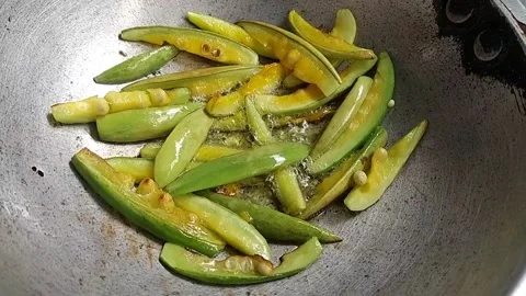Frying Pointed Gourd in a small wok Stock Footage 155157182