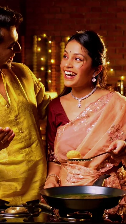 Frying poori on Diwali, Indian couple cooking together in festive kitchen Stock Footage 342382228