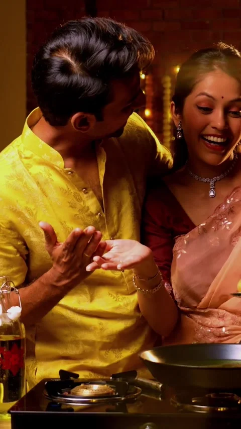 Frying poori on Diwali, Indian couple cooking together in festive kitchen Stock Footage 342382237