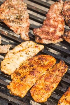 Frying pork and chicken meat on the barbecue grill Stock Photos