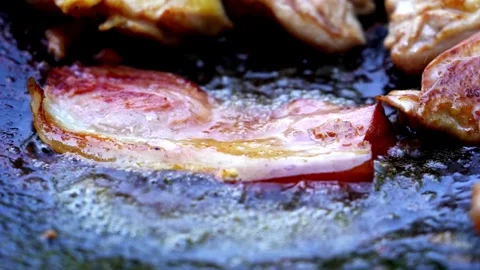 Frying pork bacon in a pan, macro view close up. Sizzling tasty bacon strips. 스톡 동영상 334643338