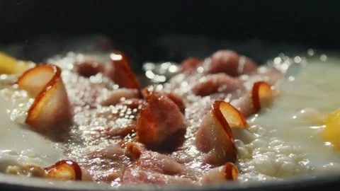 Frying pork bacon in a pan, macro view close up. Sizzling tasty bacon strips. 스톡 동영상 334643388