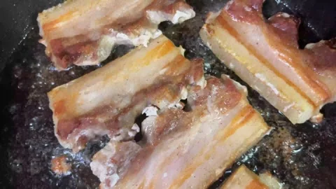 Frying pork chops in a dark used cooking oil Stock Footage 310288430